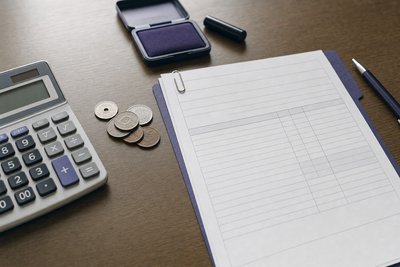 電卓と書類で専門家への依頼費用を確認するイメージ